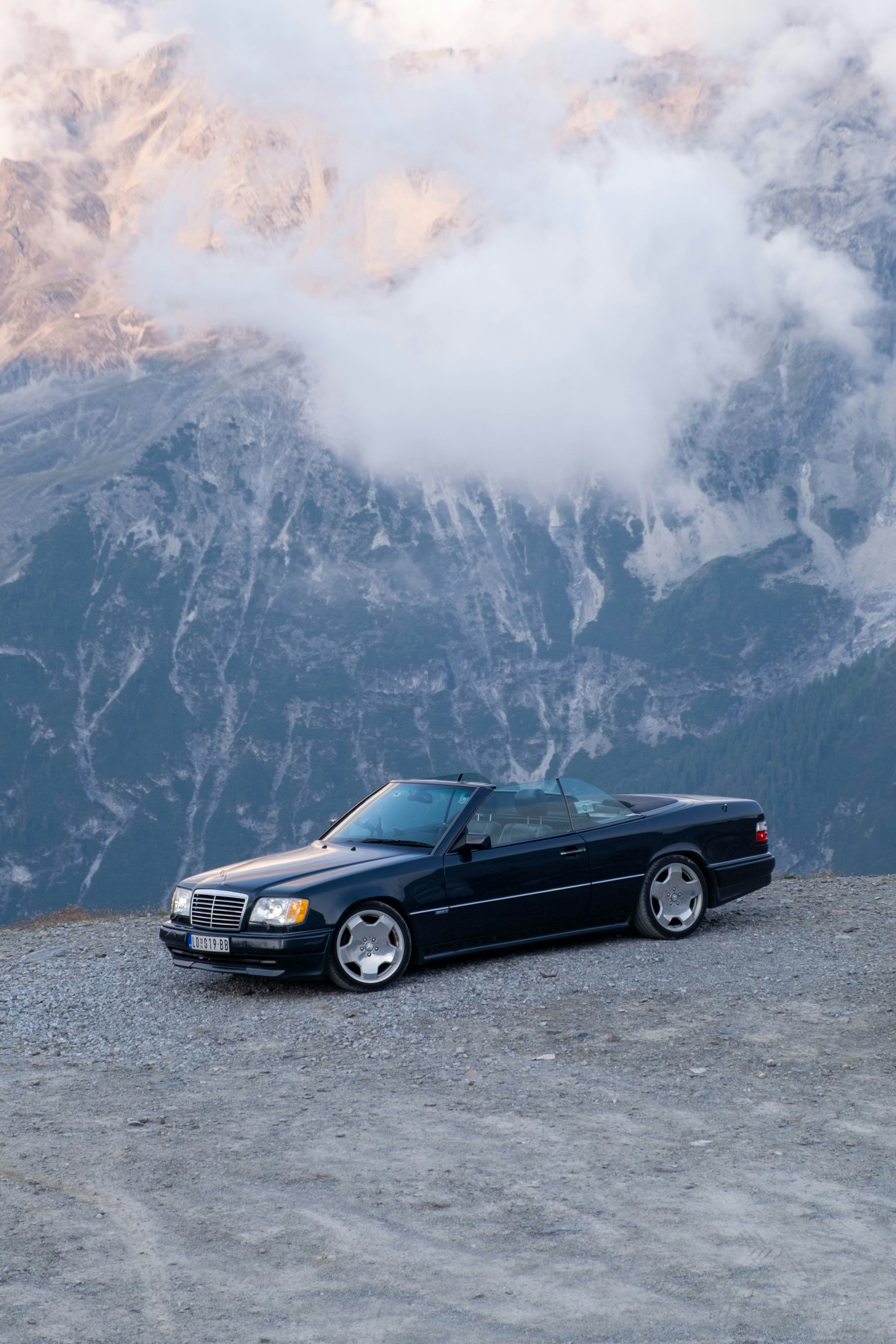 Schwarzes Cabriolet, das auf einer Bergstraße geparkt ist