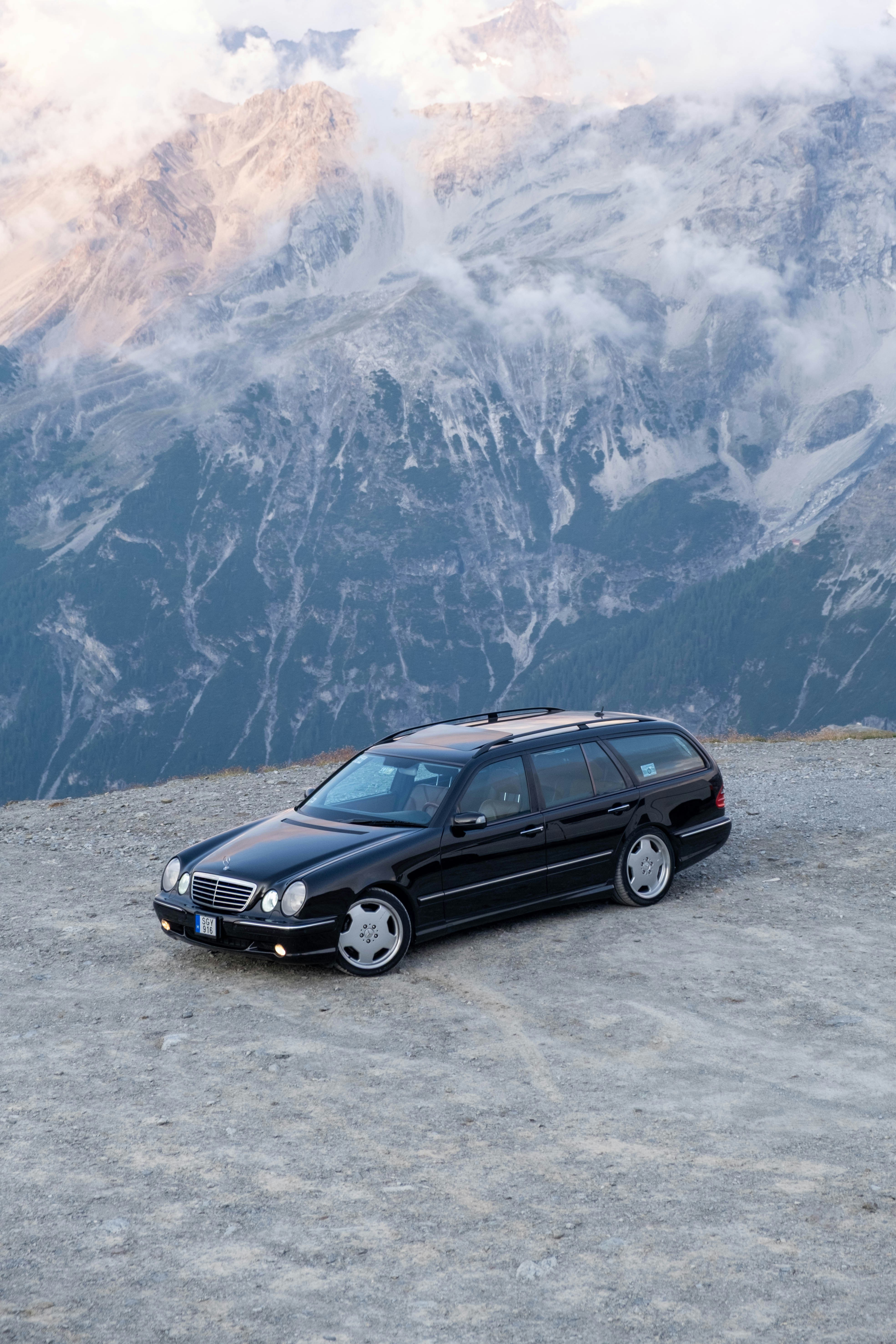 Schwarzer Kombi auf einem felsigen Bergaussichtspunkt geparkt