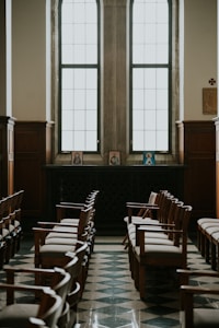 Rows of empty wooden chairs in a church hall.