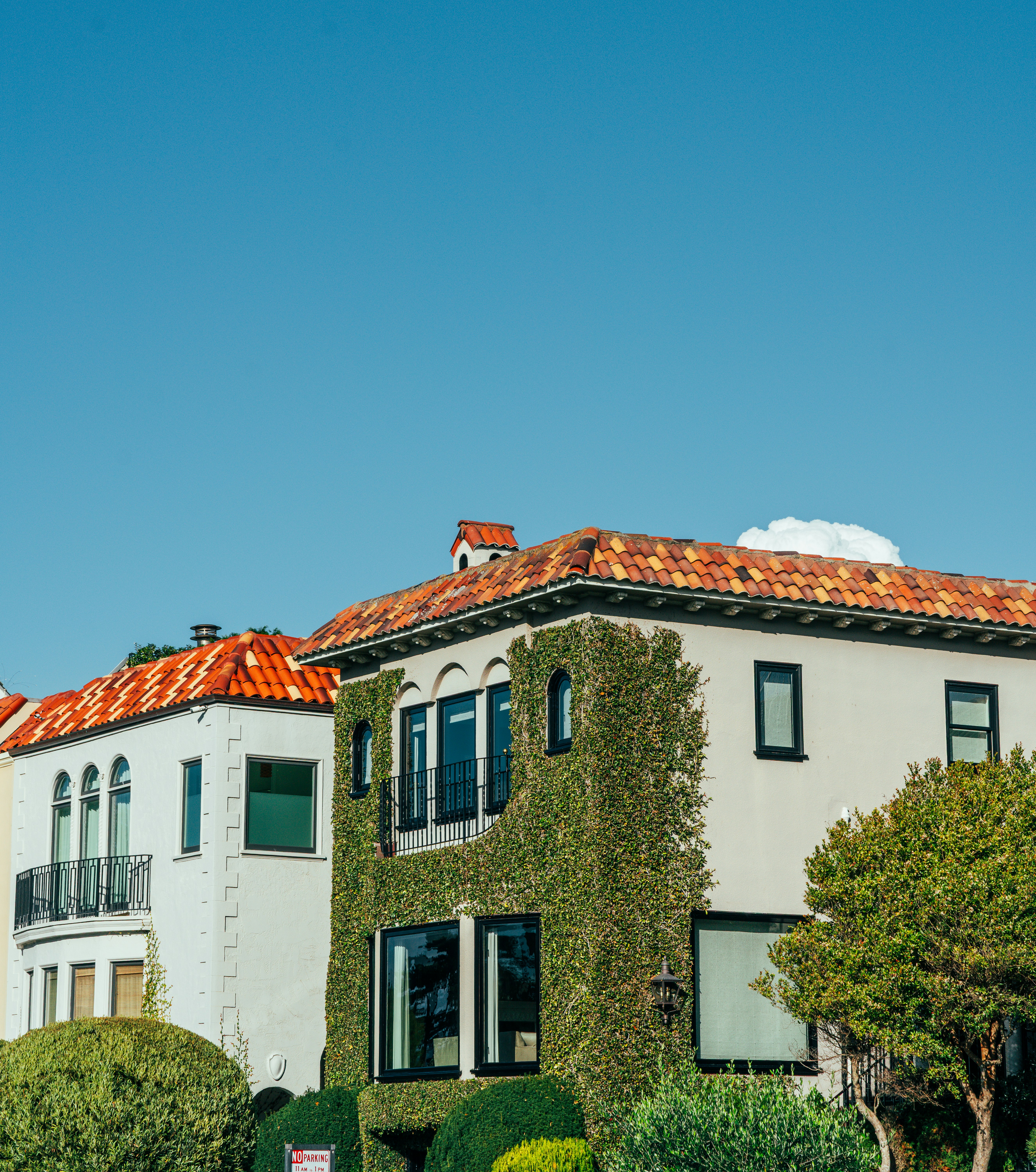 Two houses with tiled roofs under a clear sky.