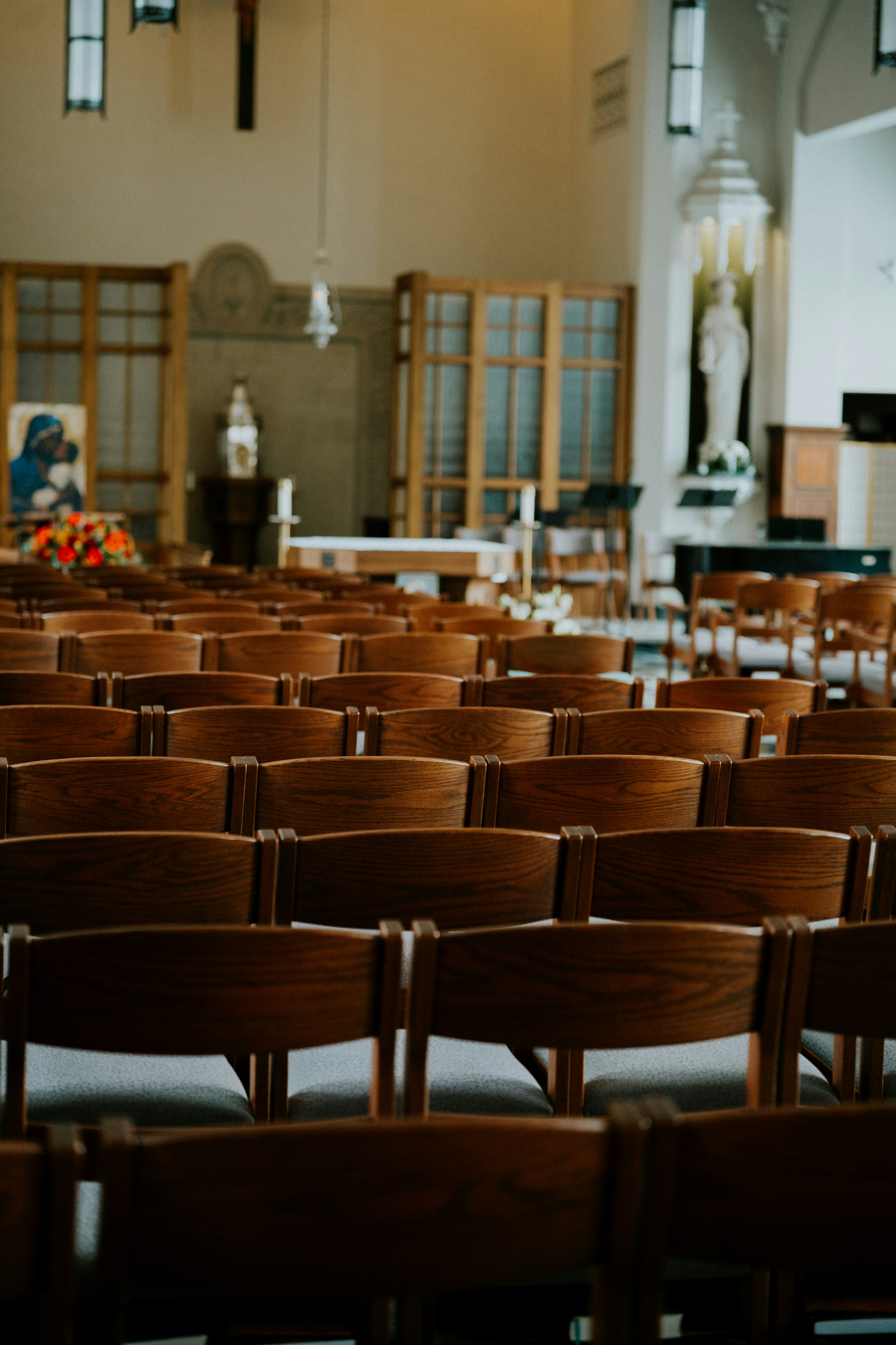 Rows of empty wooden chairs inside a church.