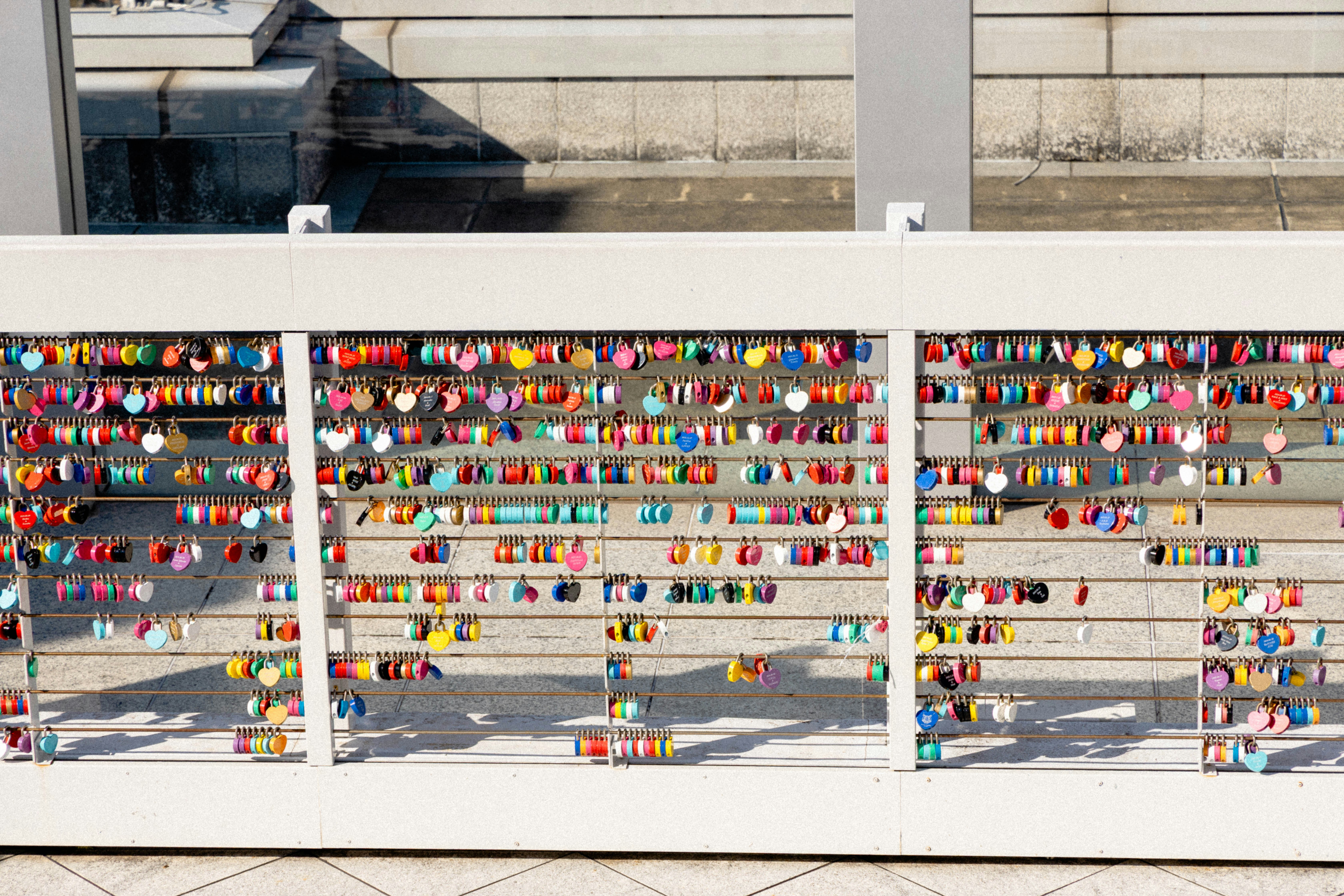 Colorful locks attached to a white railing