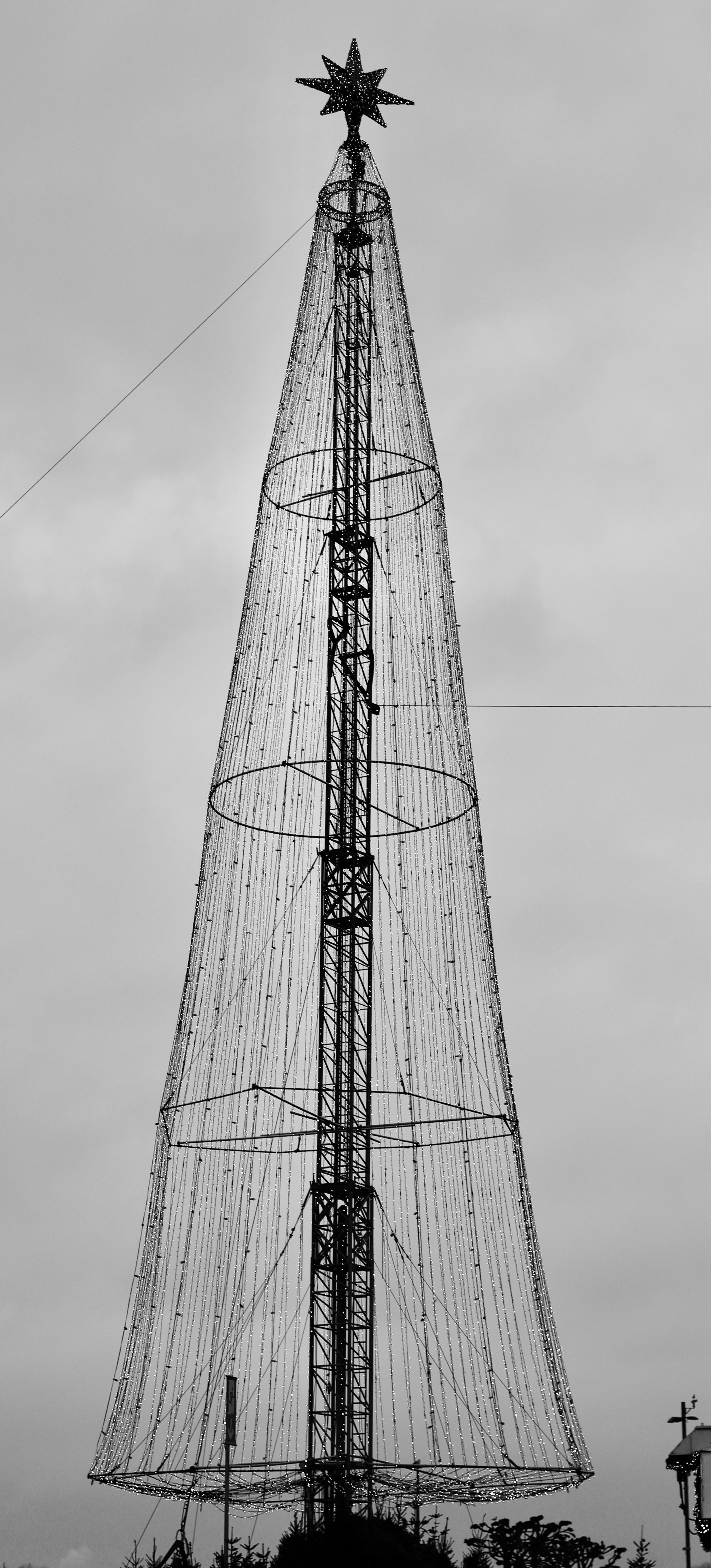 Giant illuminated christmas tree structure against cloudy sky