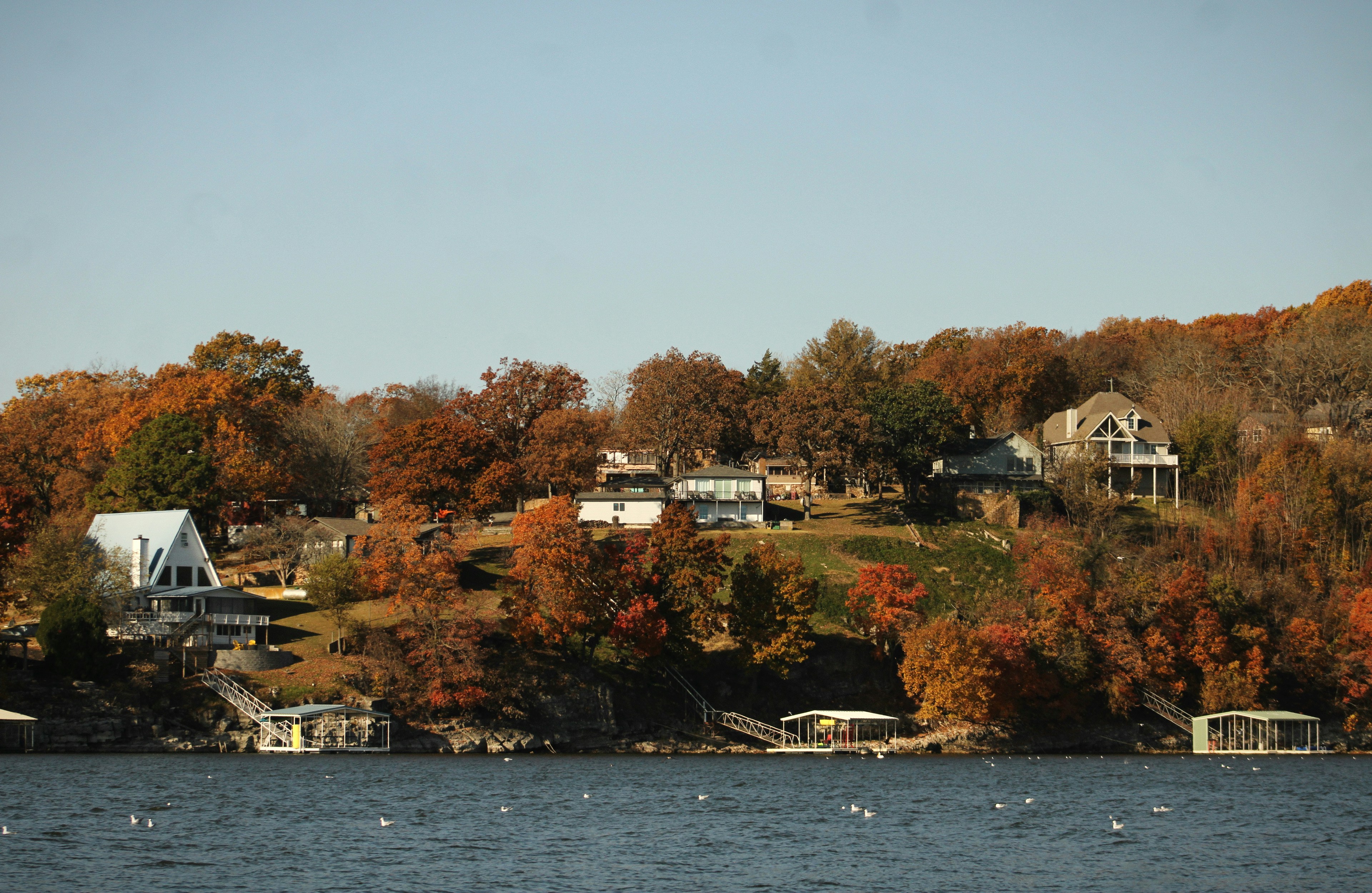 Houses on a hill overlooking a lake in autumn.