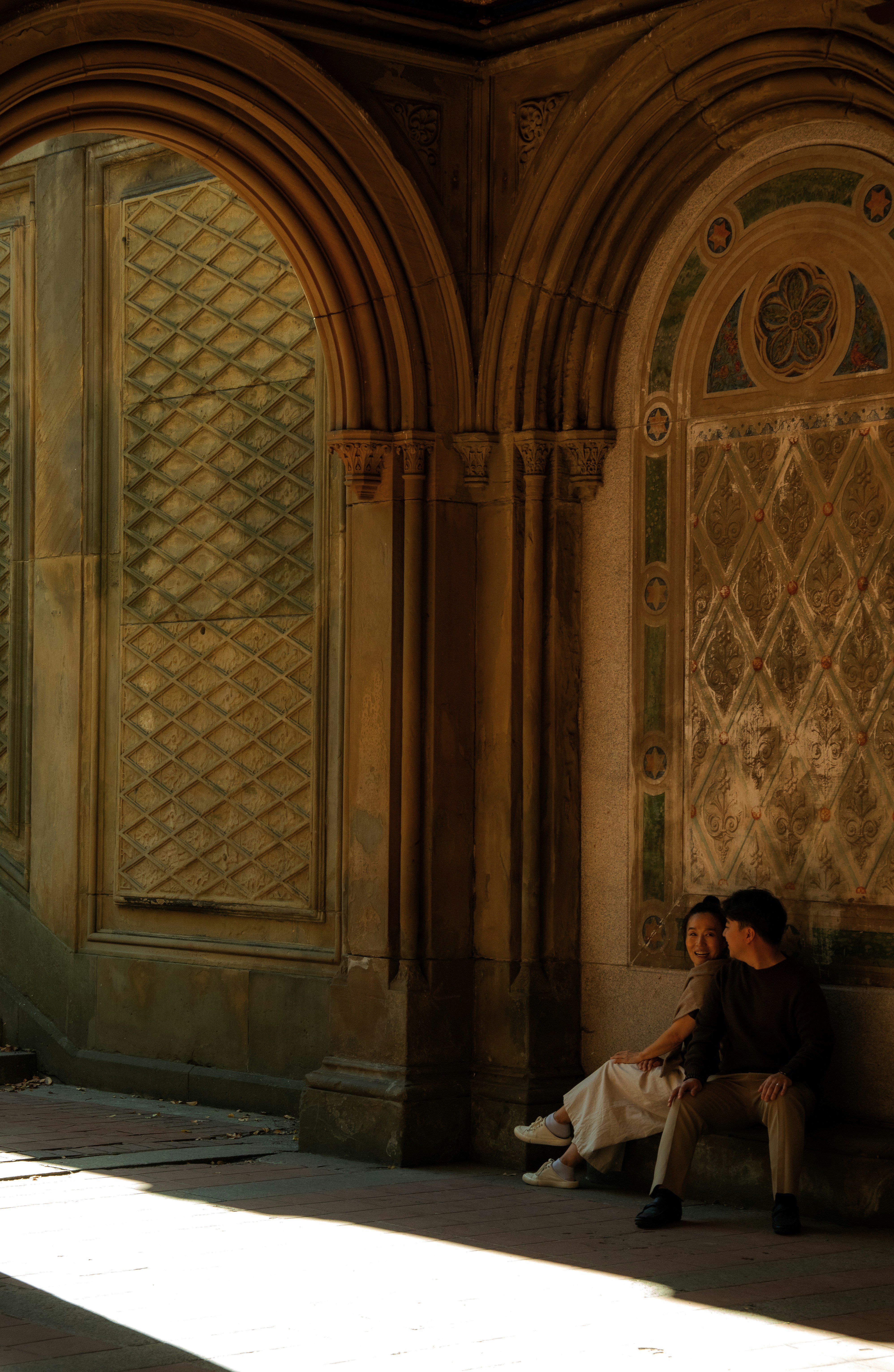 Paar, das in kunstvollen architektonischen Bögen sitzt