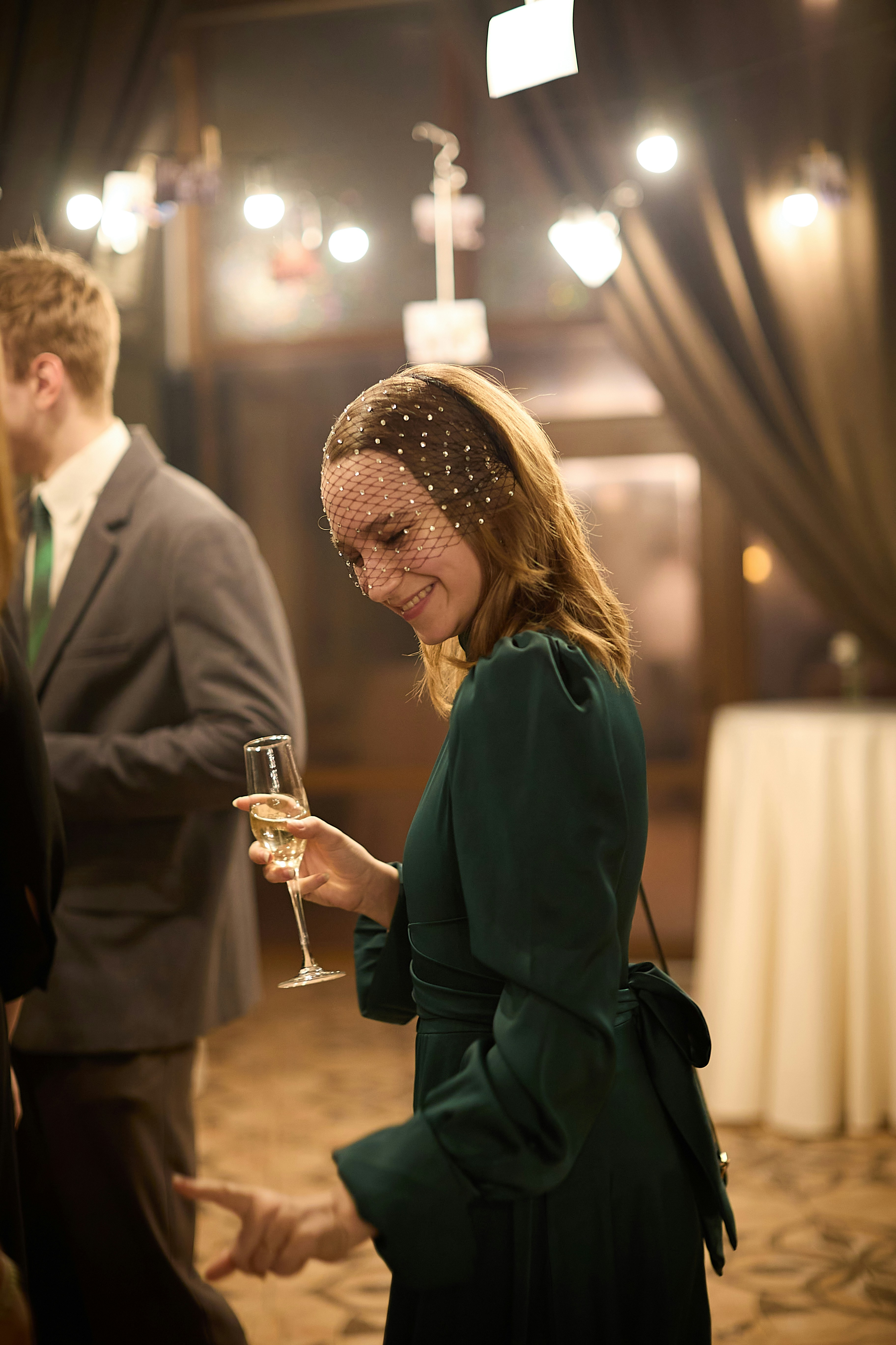 Woman in green dress holds champagne at a party.