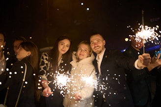 People holding sparklers at night