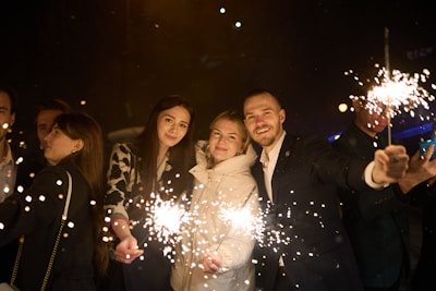 People holding sparklers at night