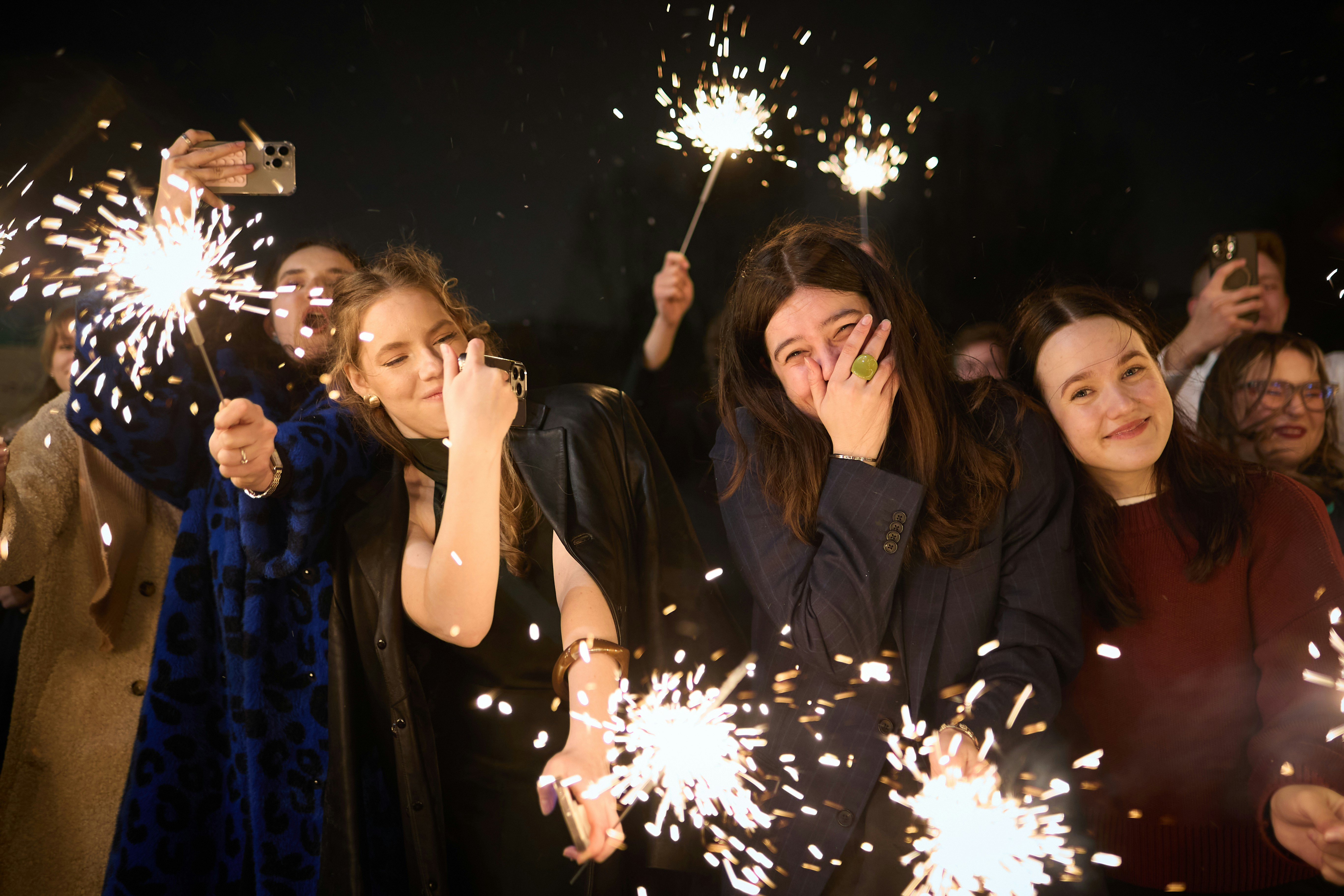People holding sparklers at night celebration