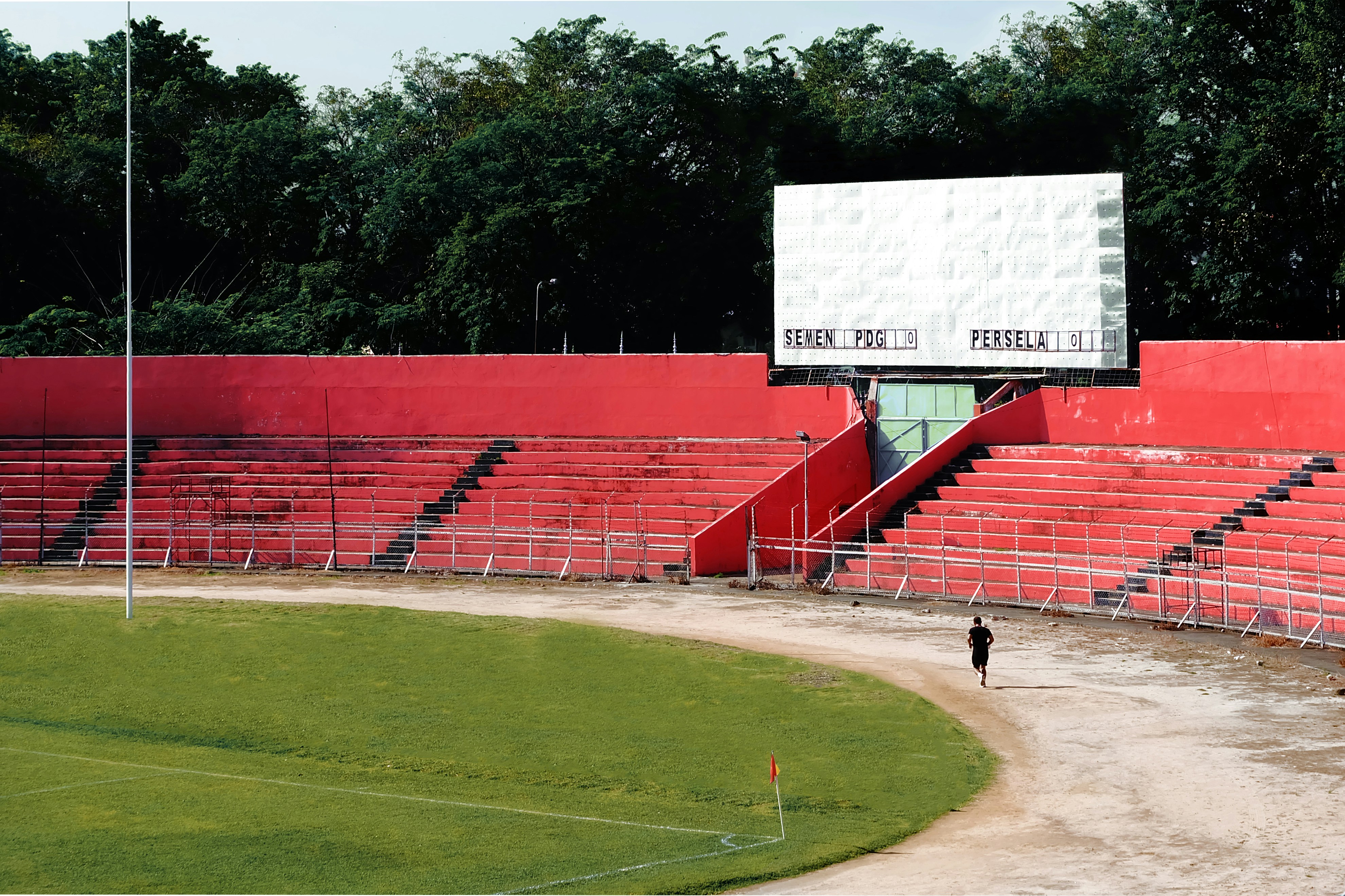 Empty stadium with a scoreboard and red seating.