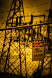 Danger high voltage sign on chain-link fence