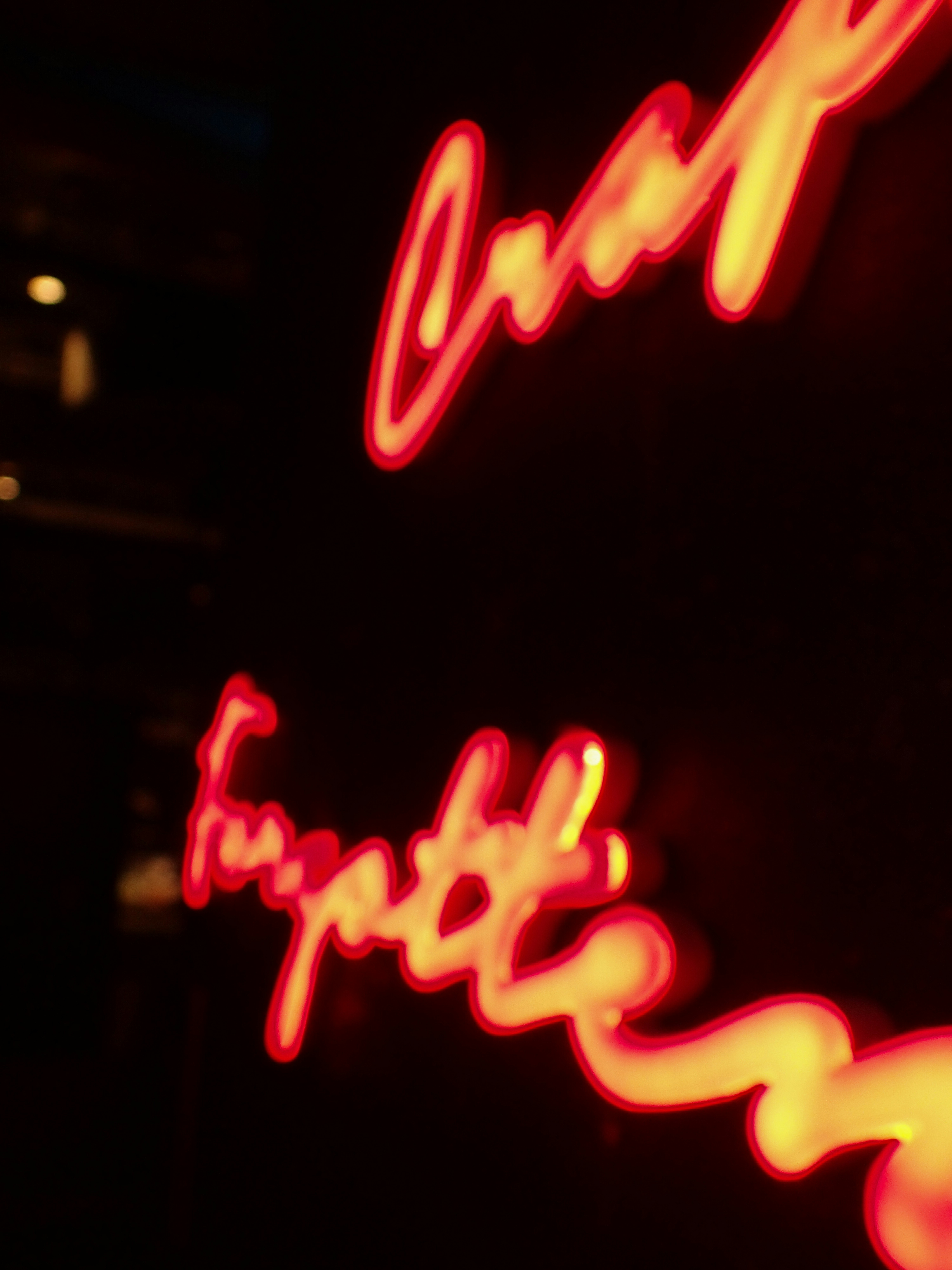 Red neon script on black background