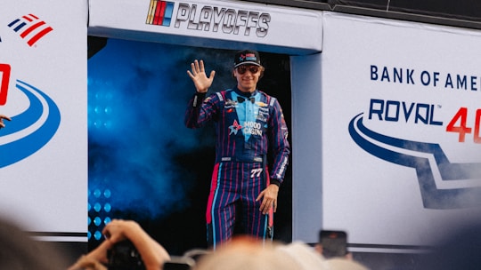 A race car driver waves to the crowd