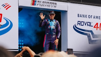 A race car driver waves to the crowd