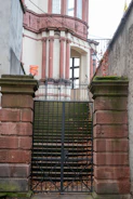 Stone pillars and gate lead to a building entrance.