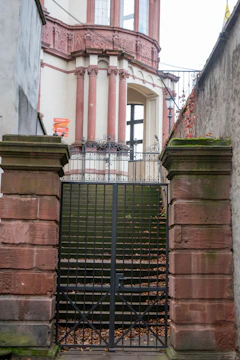 Stone pillars and gate lead to a building entrance.
