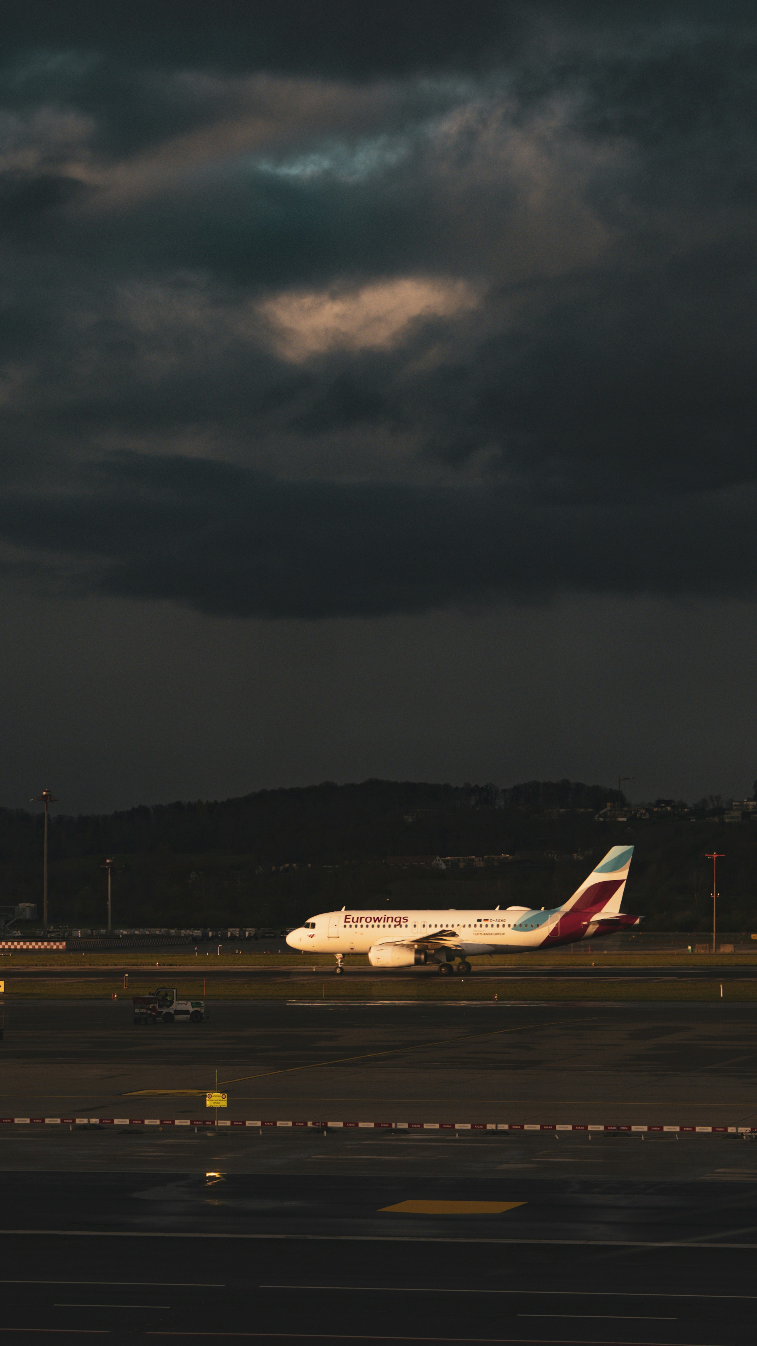 Airplane on tarmac under dramatic stormy sky