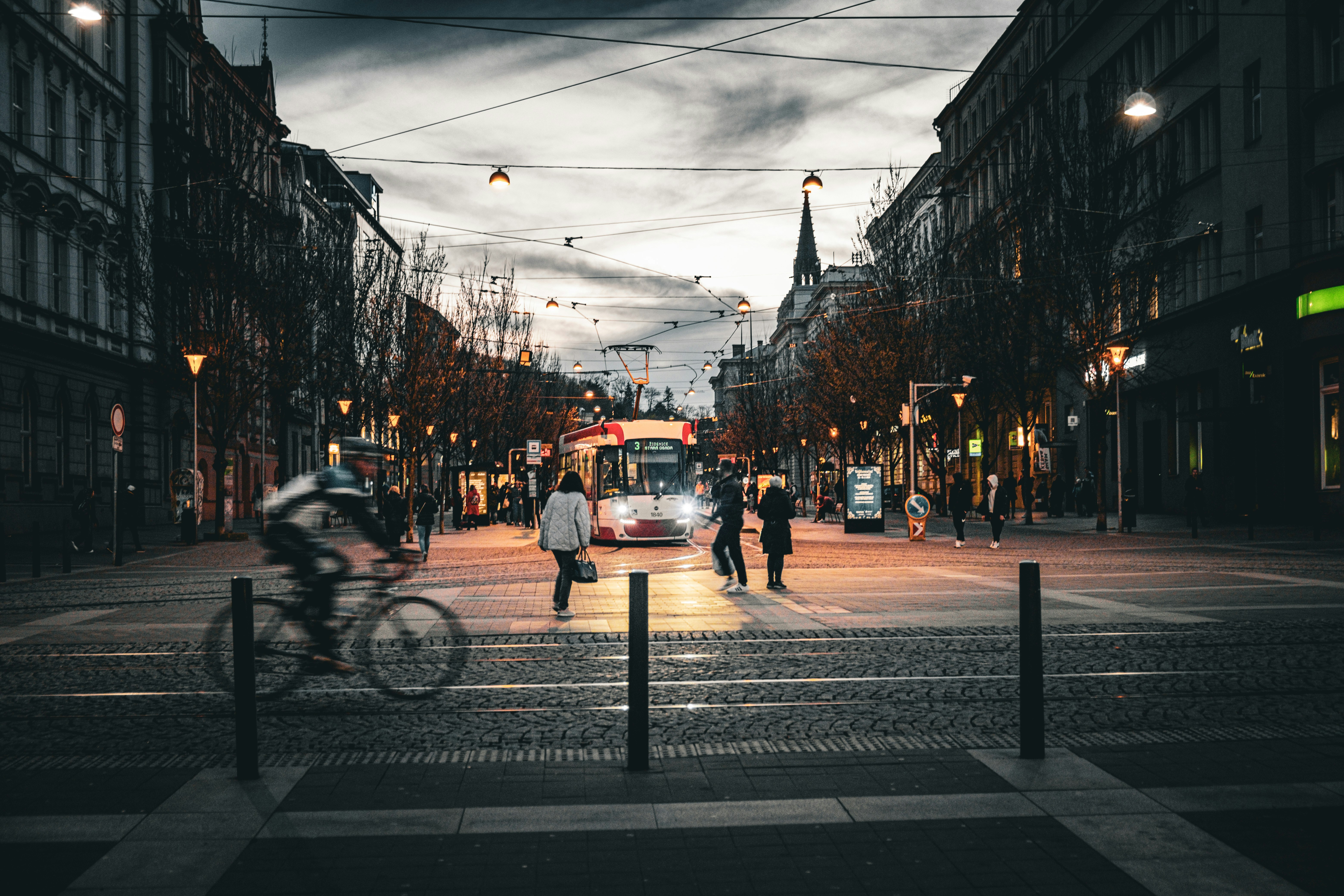 City street with people and tram at dusk