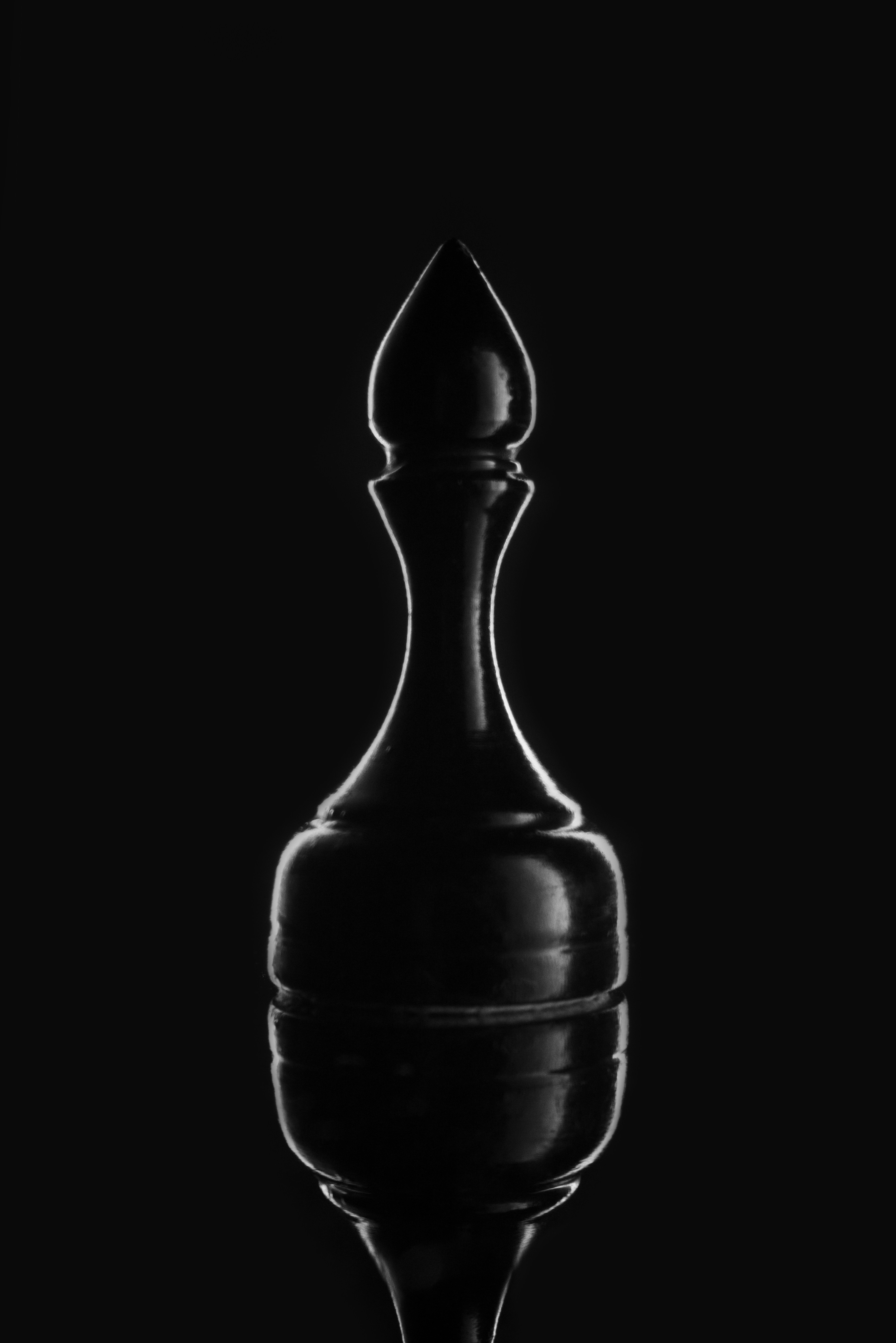 A black chess piece silhouette on a dark background.