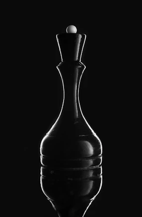 A black chess queen with a white orb on top.