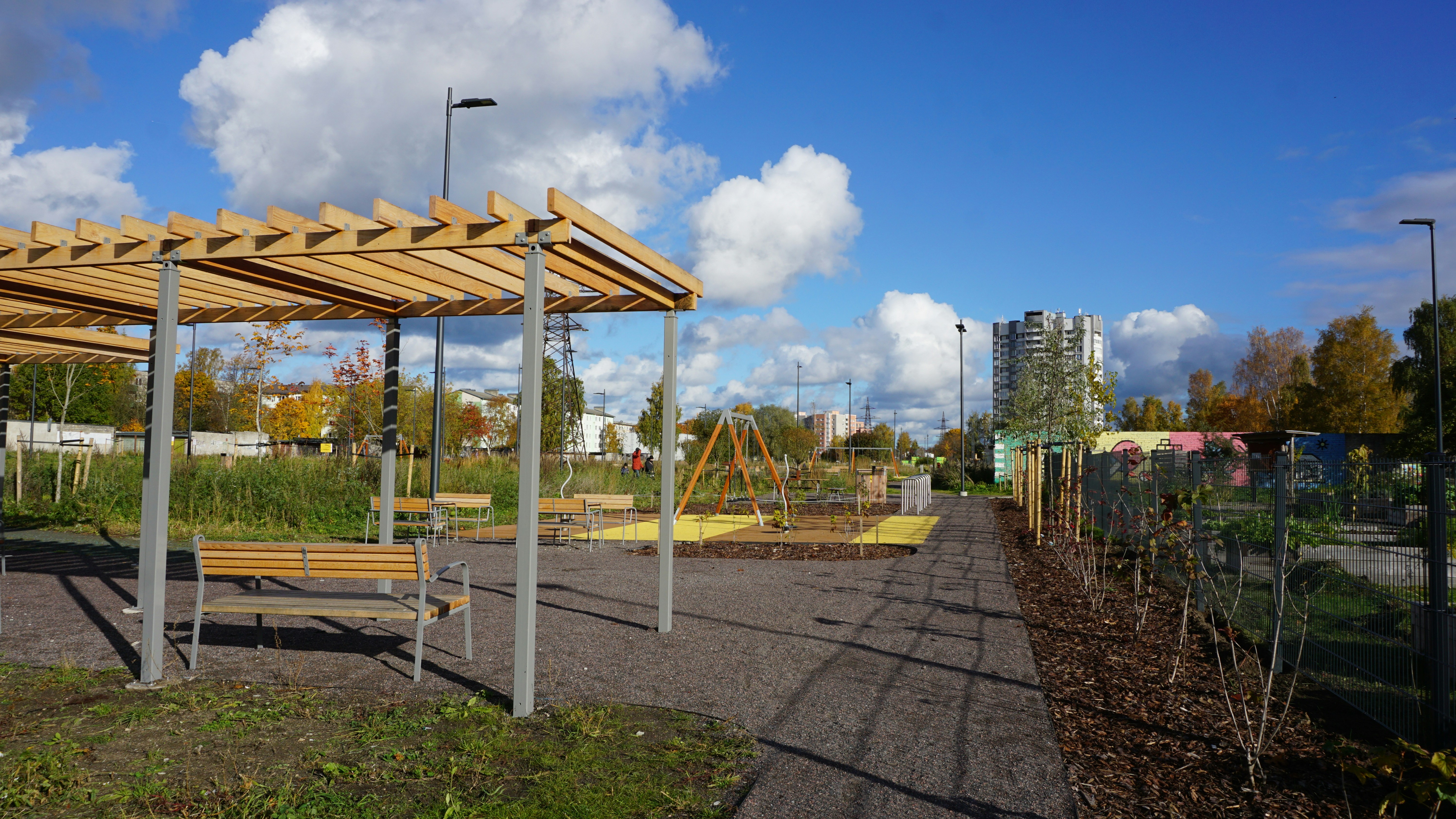 Park with wooden pergola, benches, and playground