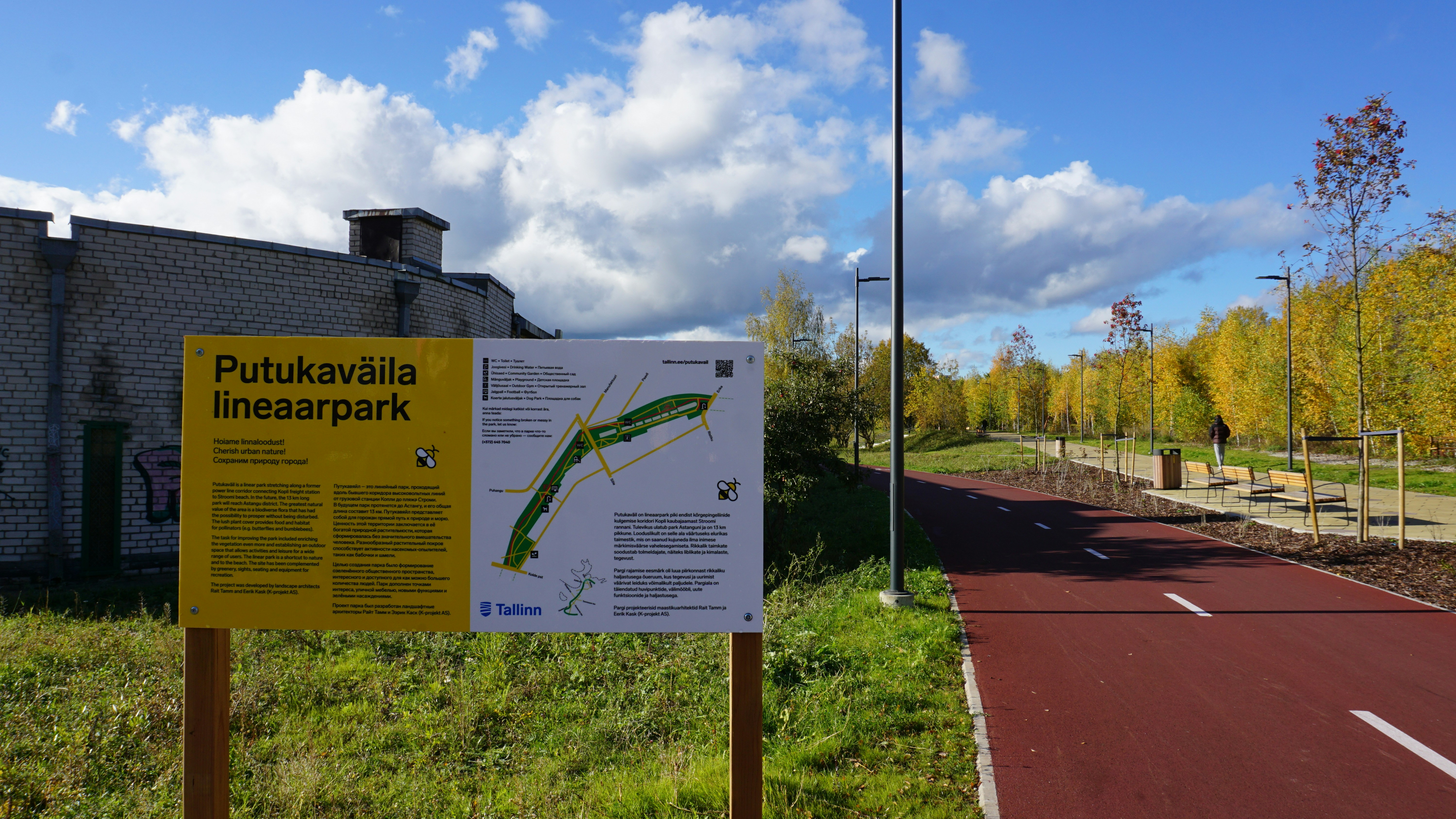 Park map sign next to a red walking path