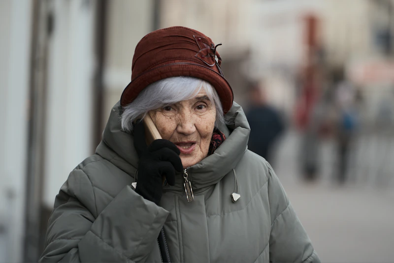 Modern äldre kvinna som håller kontakten via mobilen