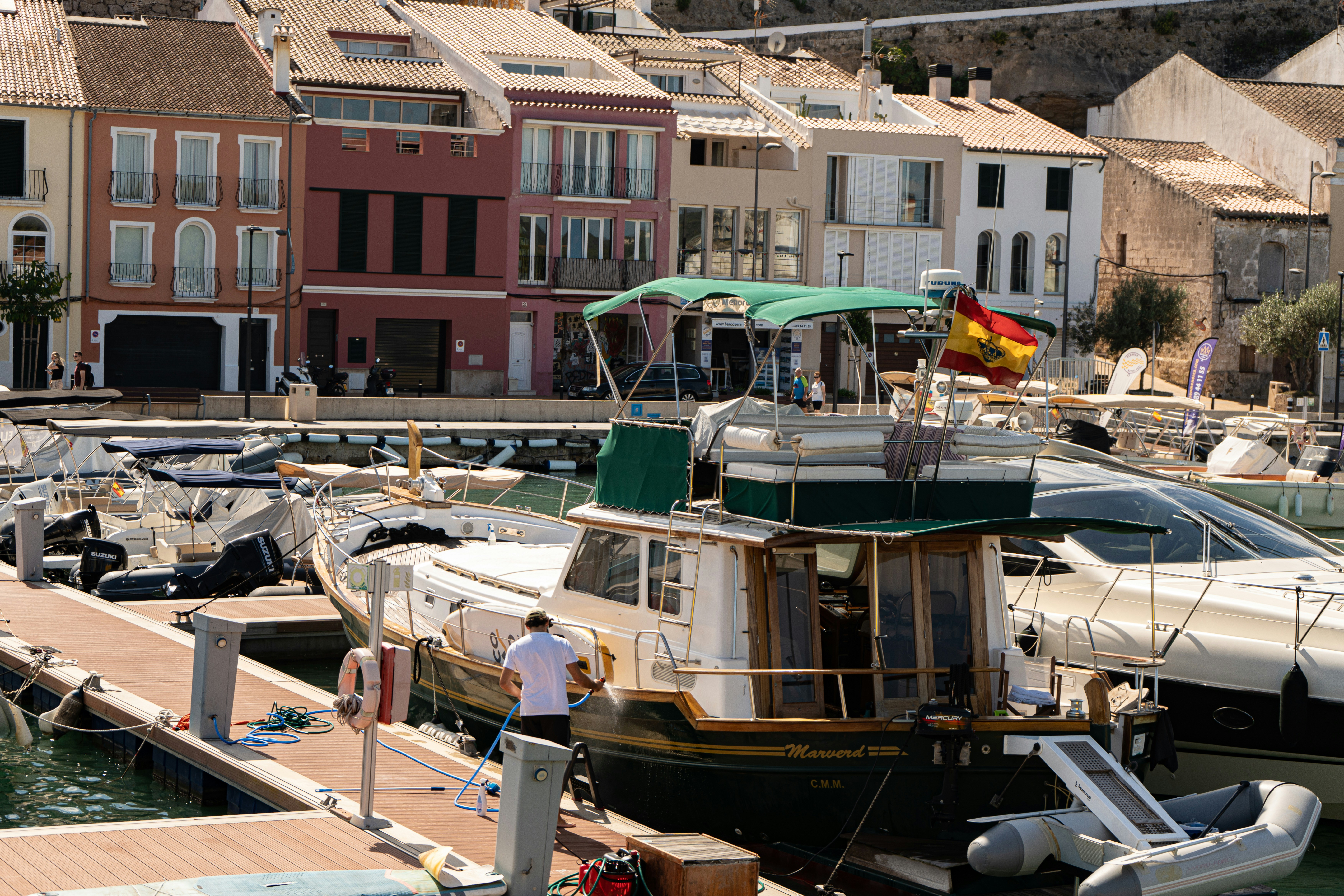 Boats docked in a harbor with colorful buildings behind.