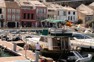 Boats docked in a harbor with colorful buildings behind.