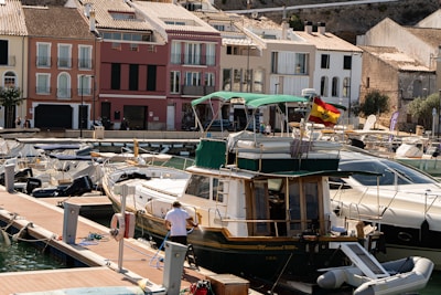 Boats docked in a harbor with colorful buildings behind.