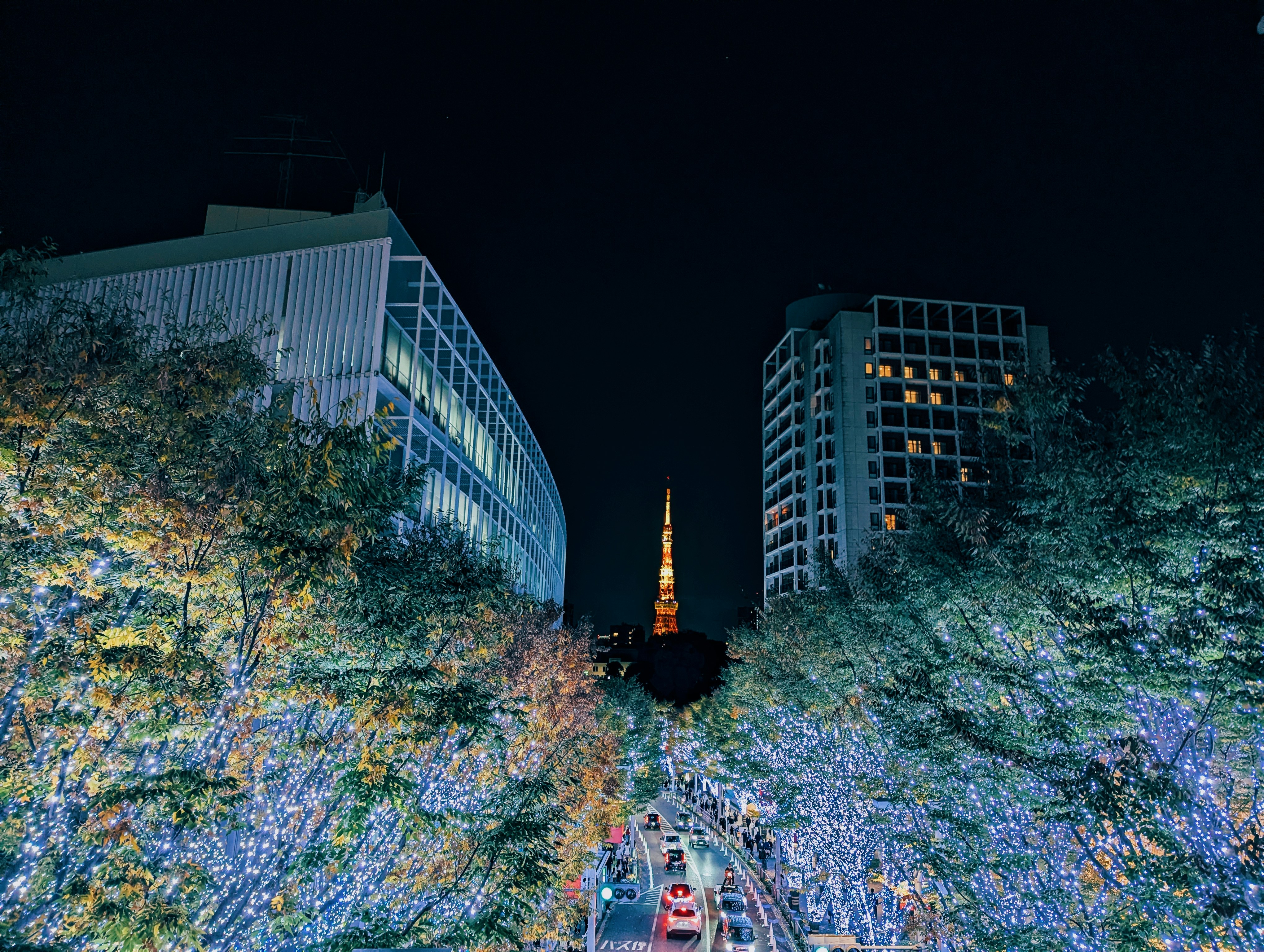 Cityscape with illuminated tower and buildings at night.
