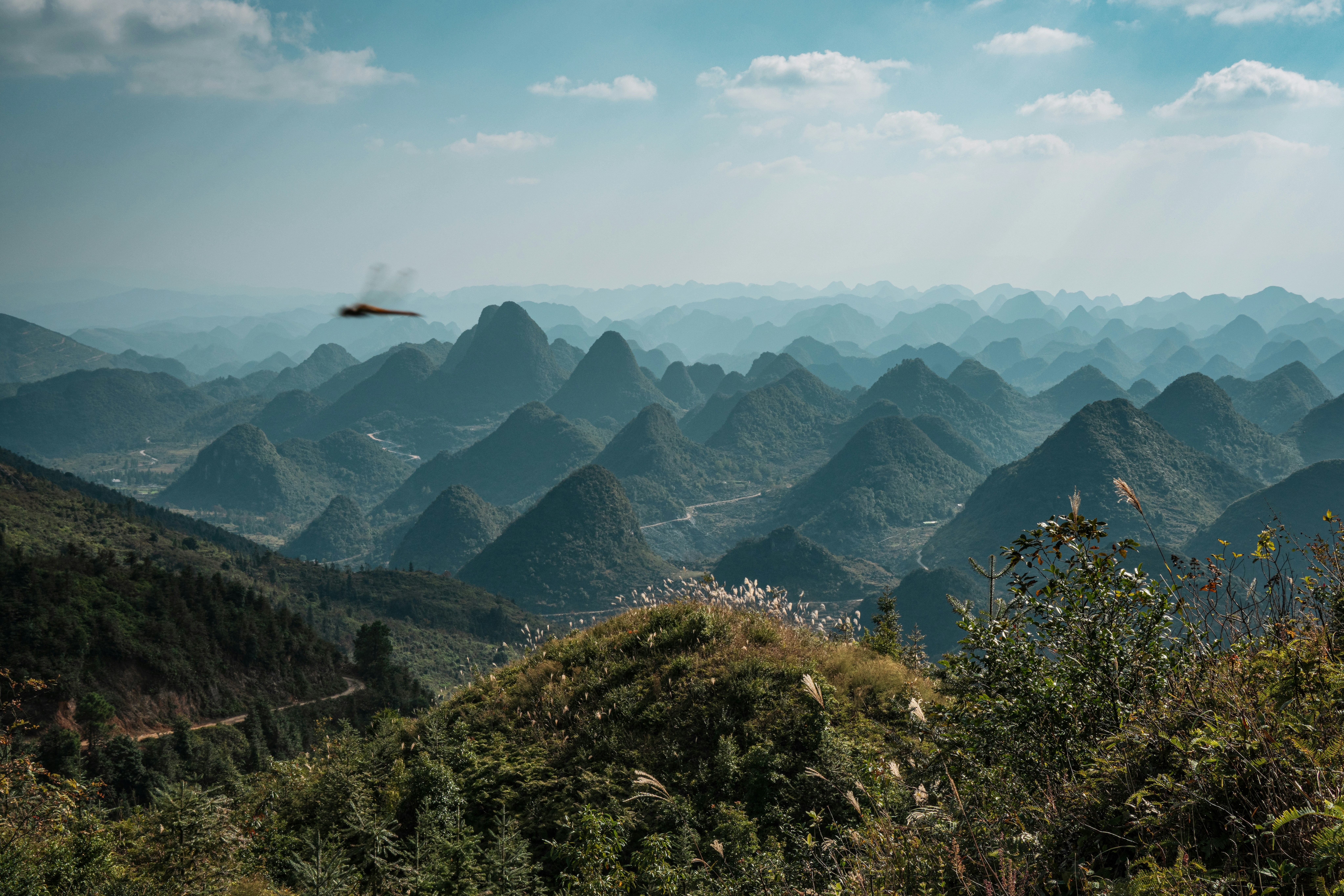 Jagged green mountains under a hazy sky
