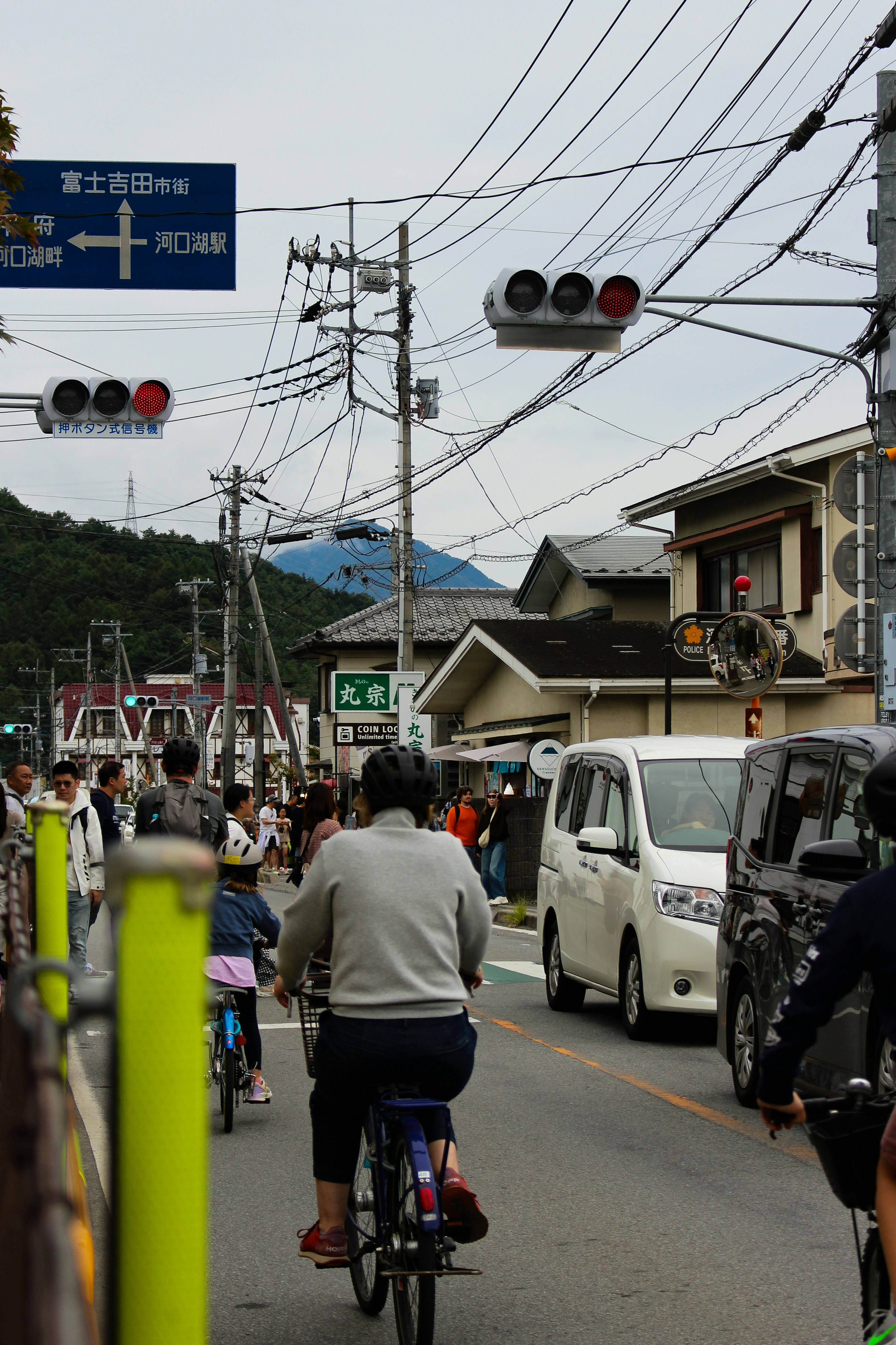 People cycling on a street with traffic lights.