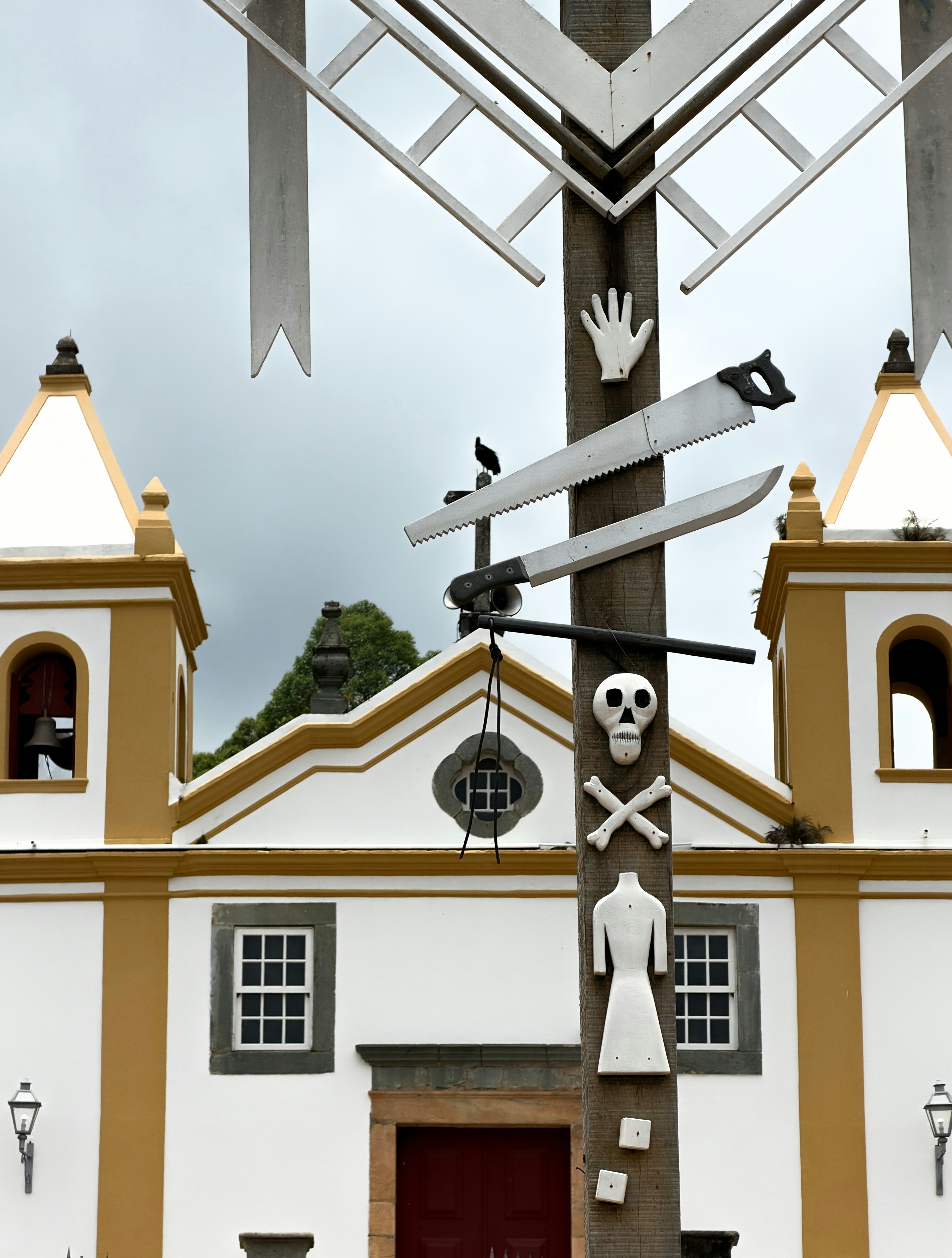 Sculpture with tools and skull in front of church