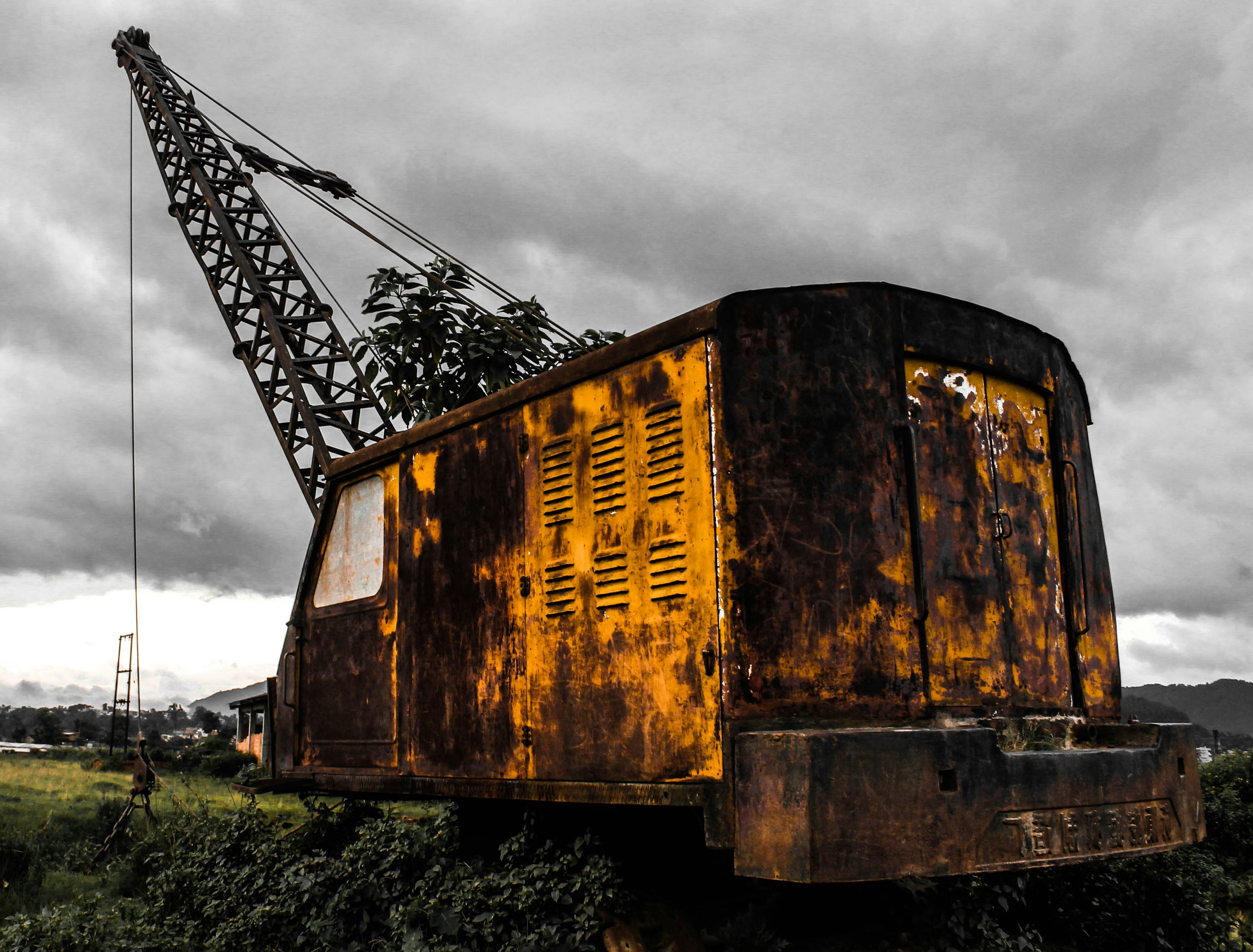 Rusty old crane sits abandoned in a field