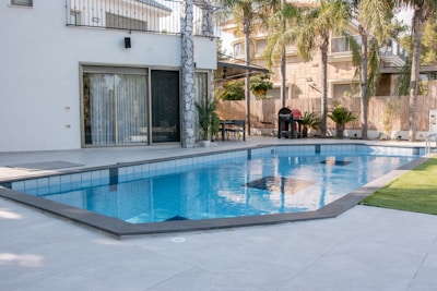 A modern house with a swimming pool and palm trees.