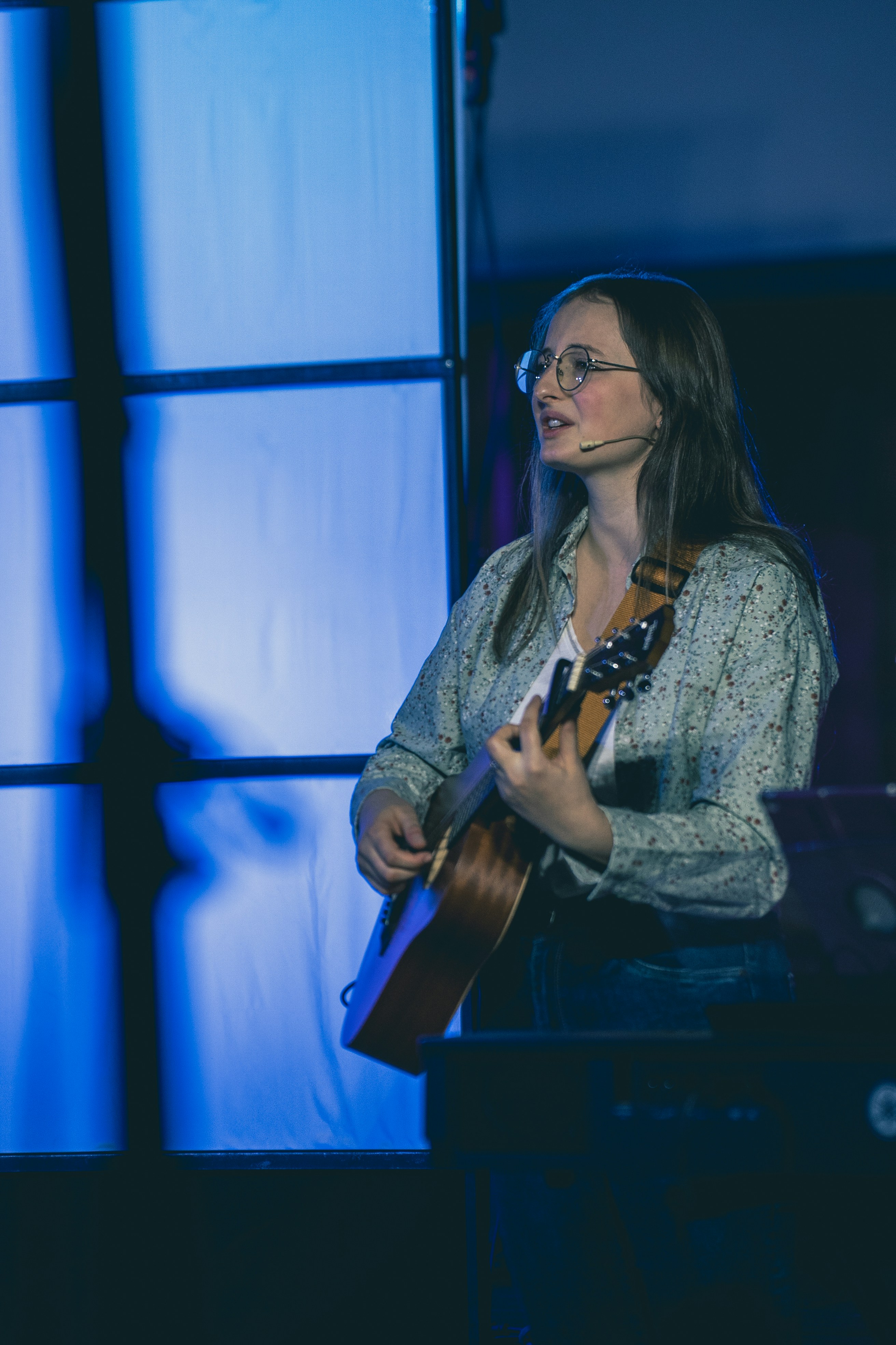 Young woman playing guitar on stage