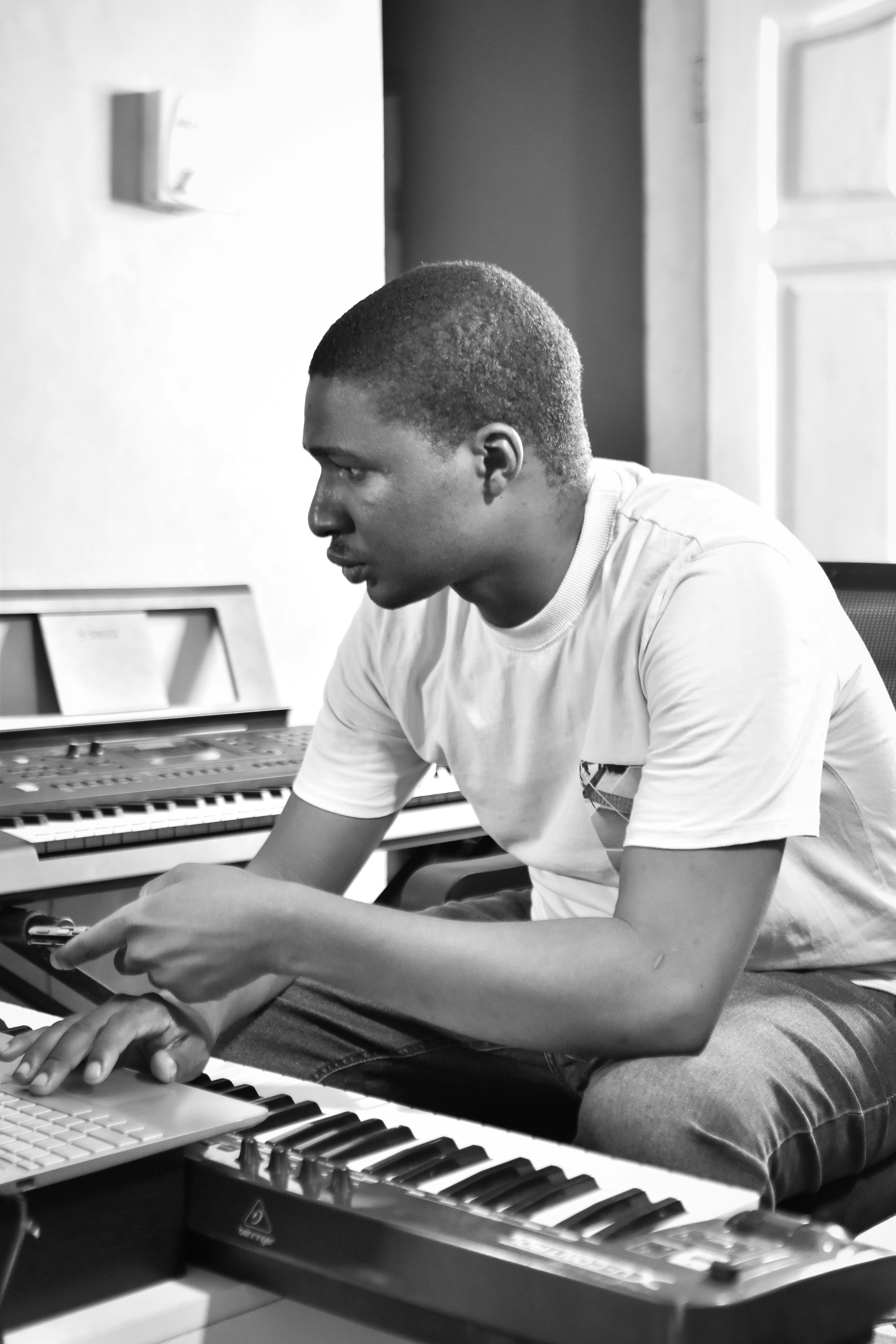 Man working on a keyboard in a music studio.