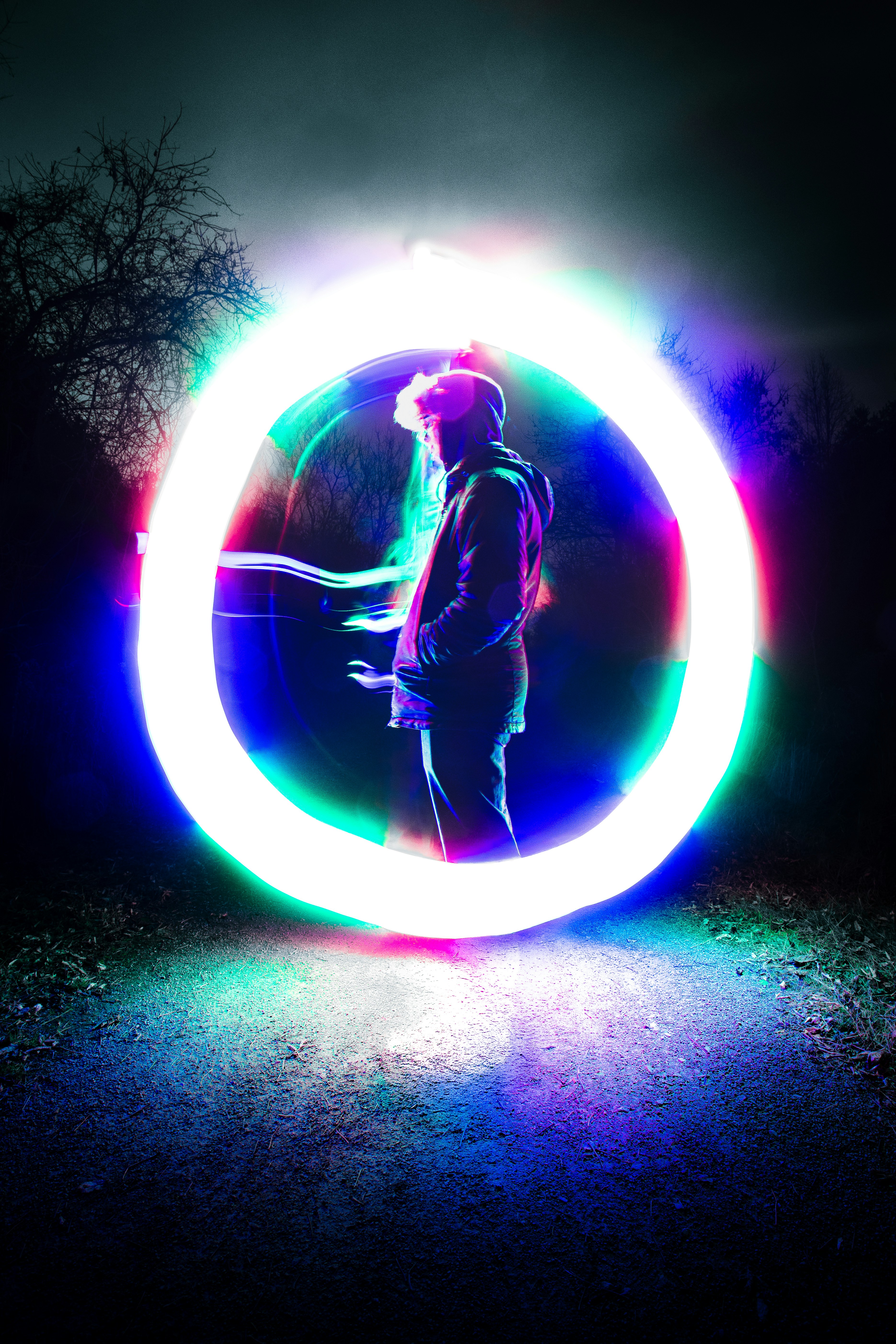 Person silhouetted within a colorful light circle
