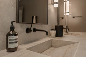 Modern bathroom with double sinks and soap dispenser.