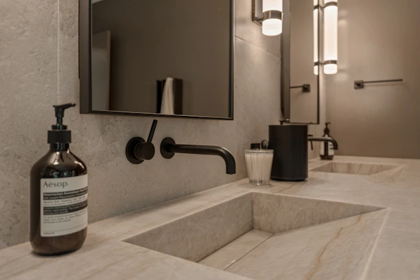 Modern bathroom with double sinks and soap dispenser.