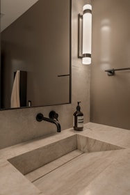Modern bathroom with stone sink and black faucet.