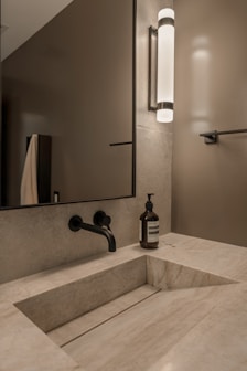 Modern bathroom with stone sink and black faucet.
