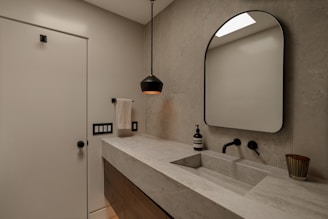Modern bathroom with concrete sink and black faucet.