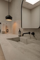 Modern bathroom with a stone sink and black faucet.