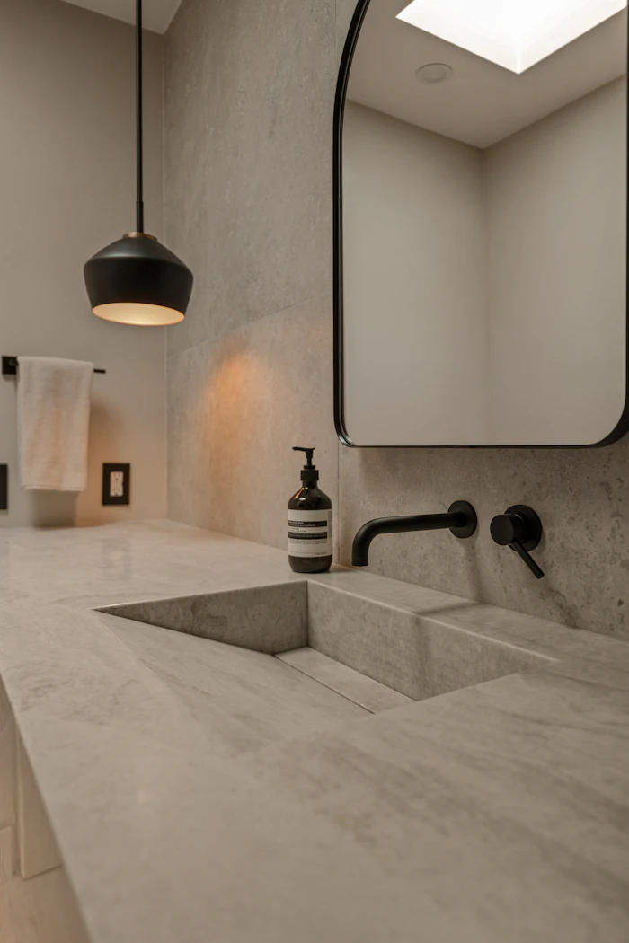 Honed stone basin with a matte black tap