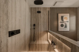 Modern bathroom with stone tile and recessed lighting.