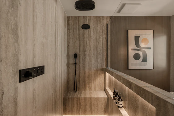 Modern bathroom with stone tile and recessed lighting.