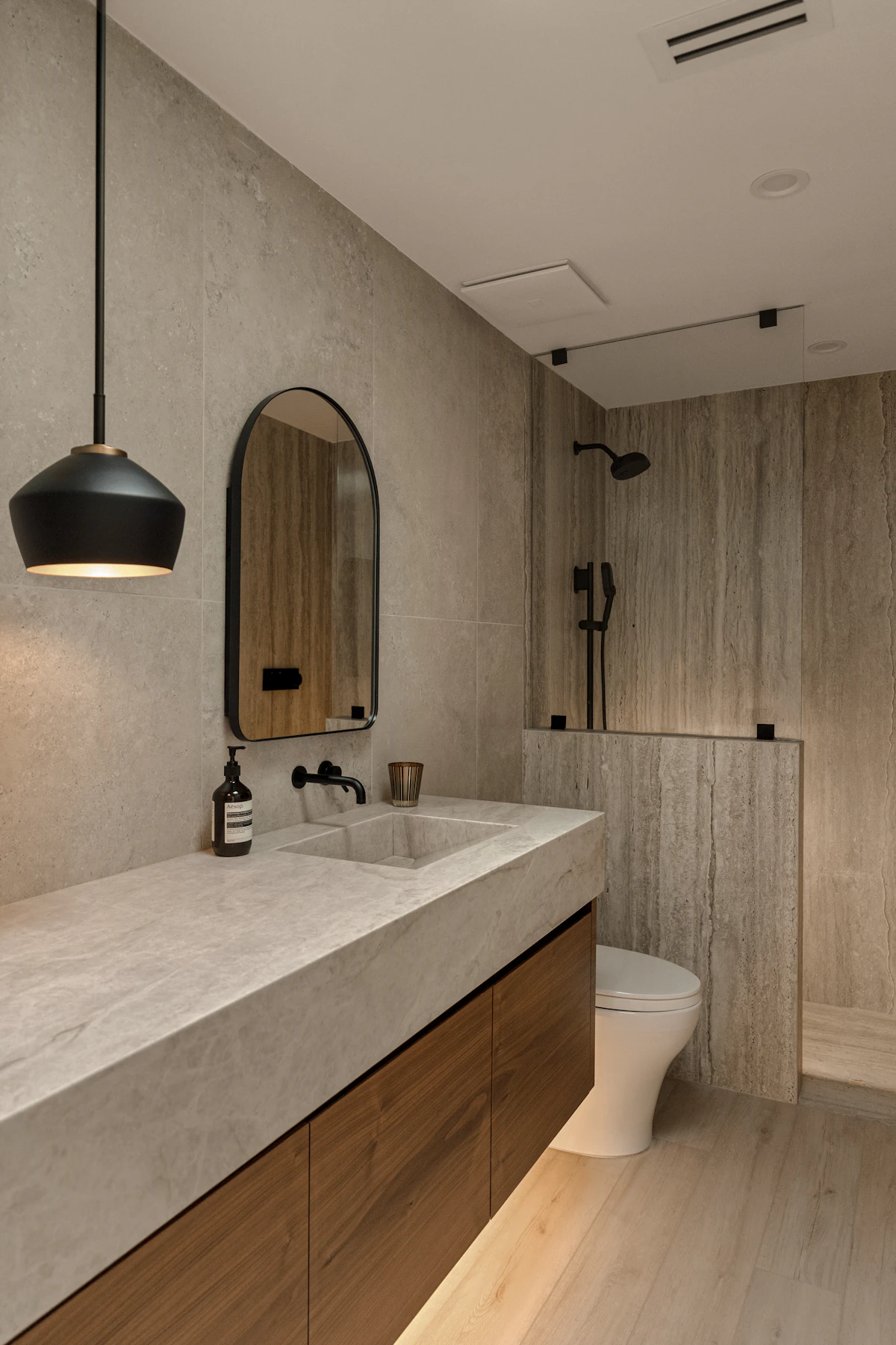 Baño contemporáneo con piedra, madera y grifería negra