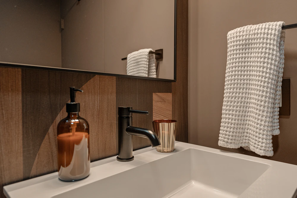 Clean modern bathroom sink with towel and soap dispenser